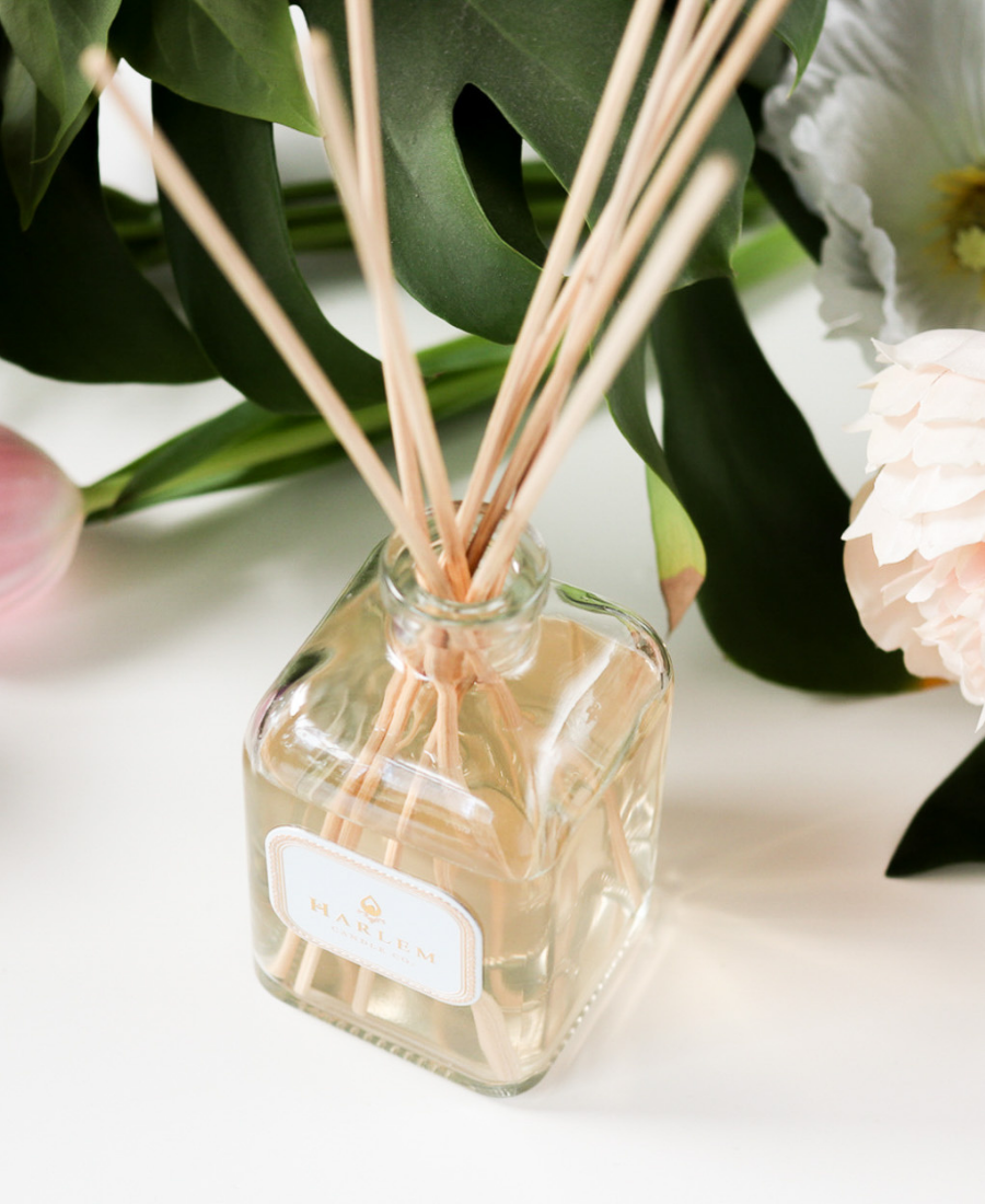 Dream Reed Diffuser on a white table with flowers.