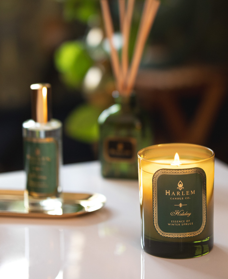 Holiday Candle on a white table with the Holiday Room and Linen Spray and Diffuser.
