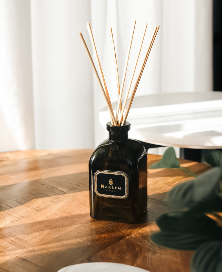 Holiday Reed Diffuser on a wooden table with greenery.