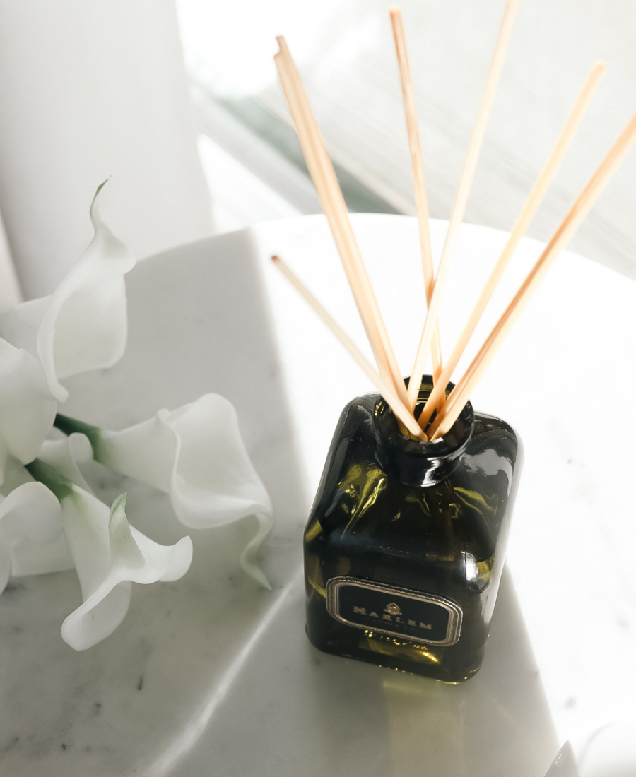 Holiday Reed Diffuser on a white table with white flowers.