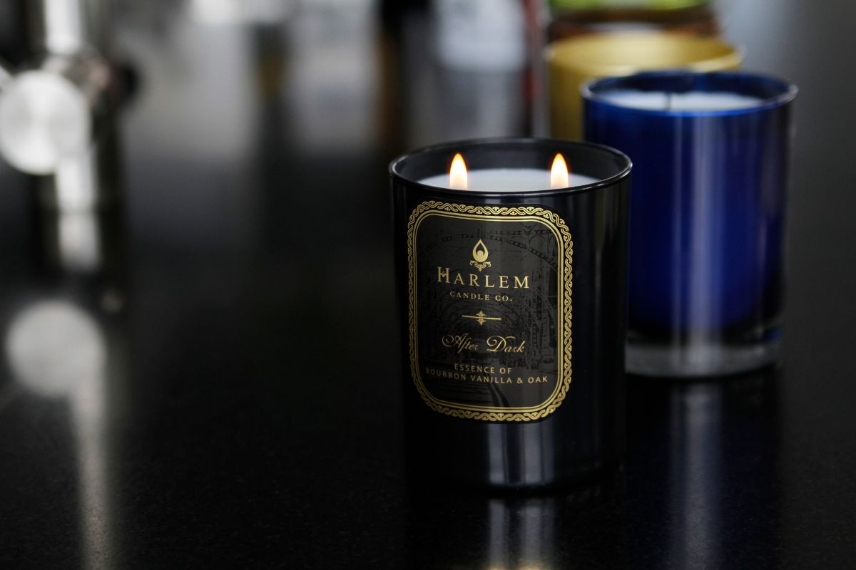 This is a Lifestyle image of the black and gold After Dark candle in a beautiful setting with other candles in the background.