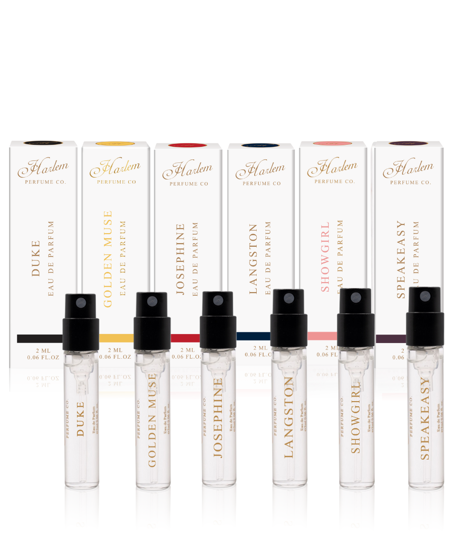Set of small perfume bottles with black caps and visible brand names on a white background.