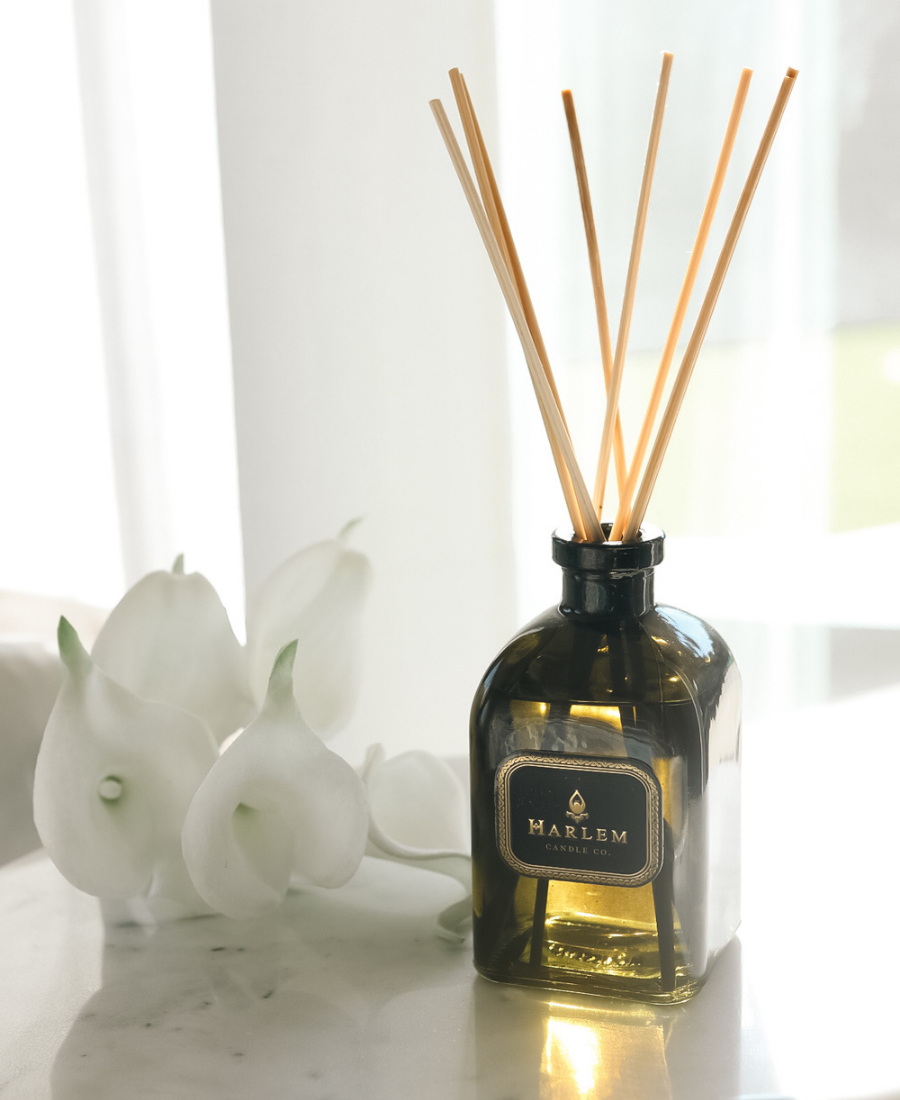 Holiday Reed Diffuser on a white table with white flowers.