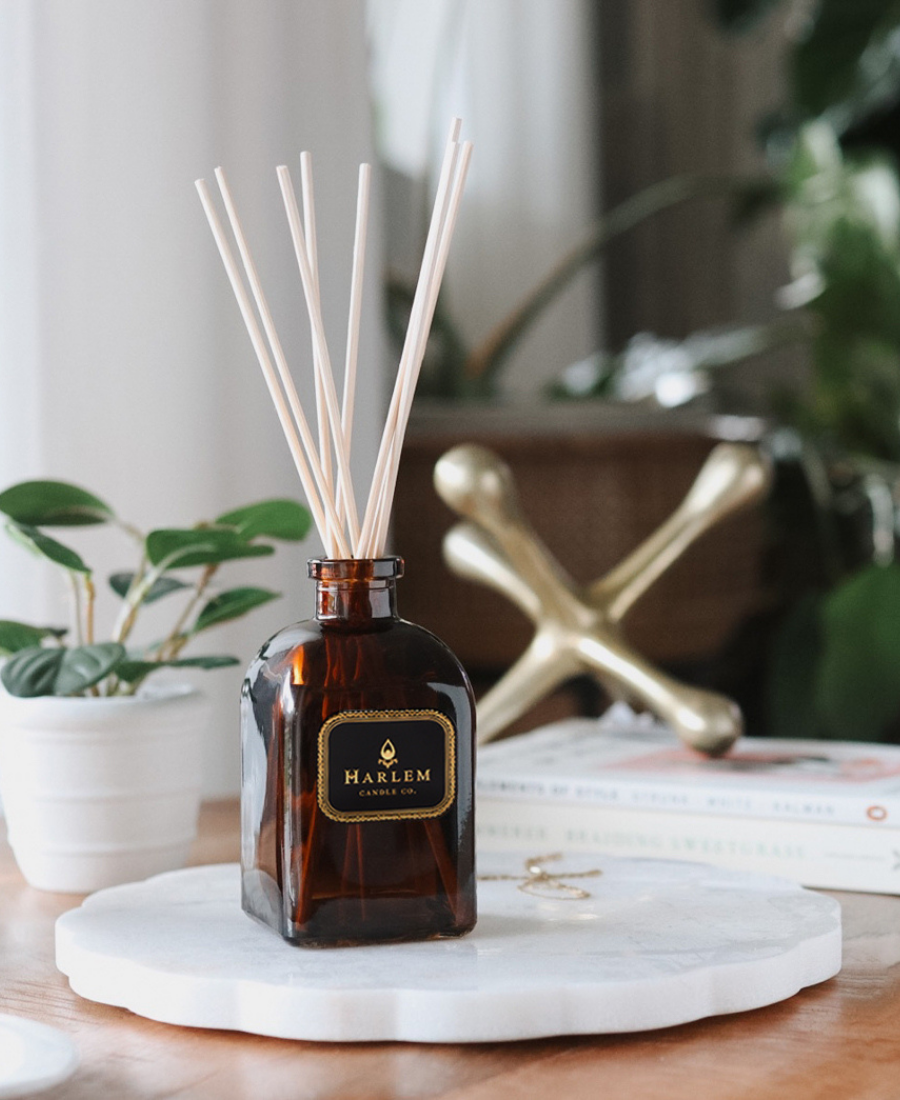 Savoy Reed Diffuser on a marble tray with books, greenery, jewelry, and a gold paperweight.