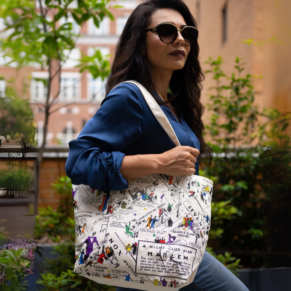 Woman holding a tote bag with a colorful design in an outdoor setting